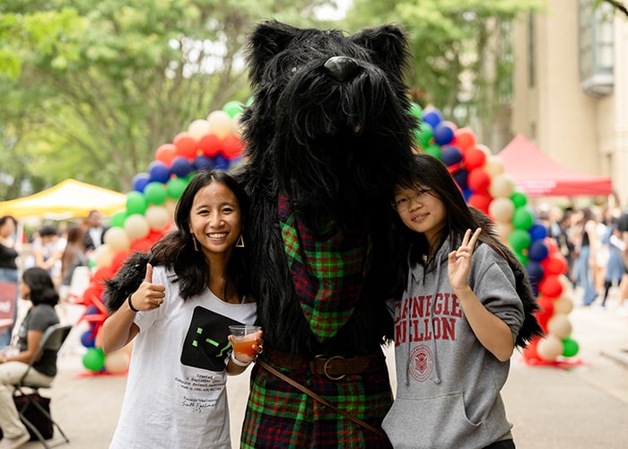 Students pose with mascot Scotty on the East West Walkway during Scotty Saturday