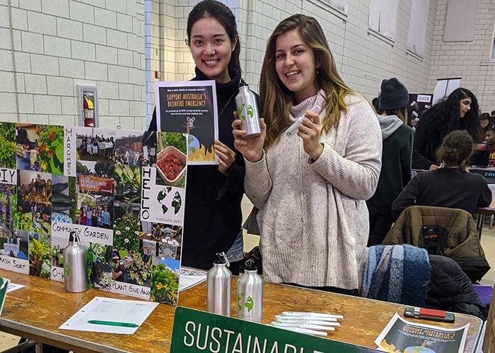 Sustainable Earth student organization members smile at their table at The Winter Fair.