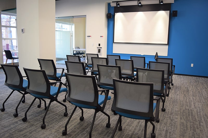 chairs facing a white board and a blue wall