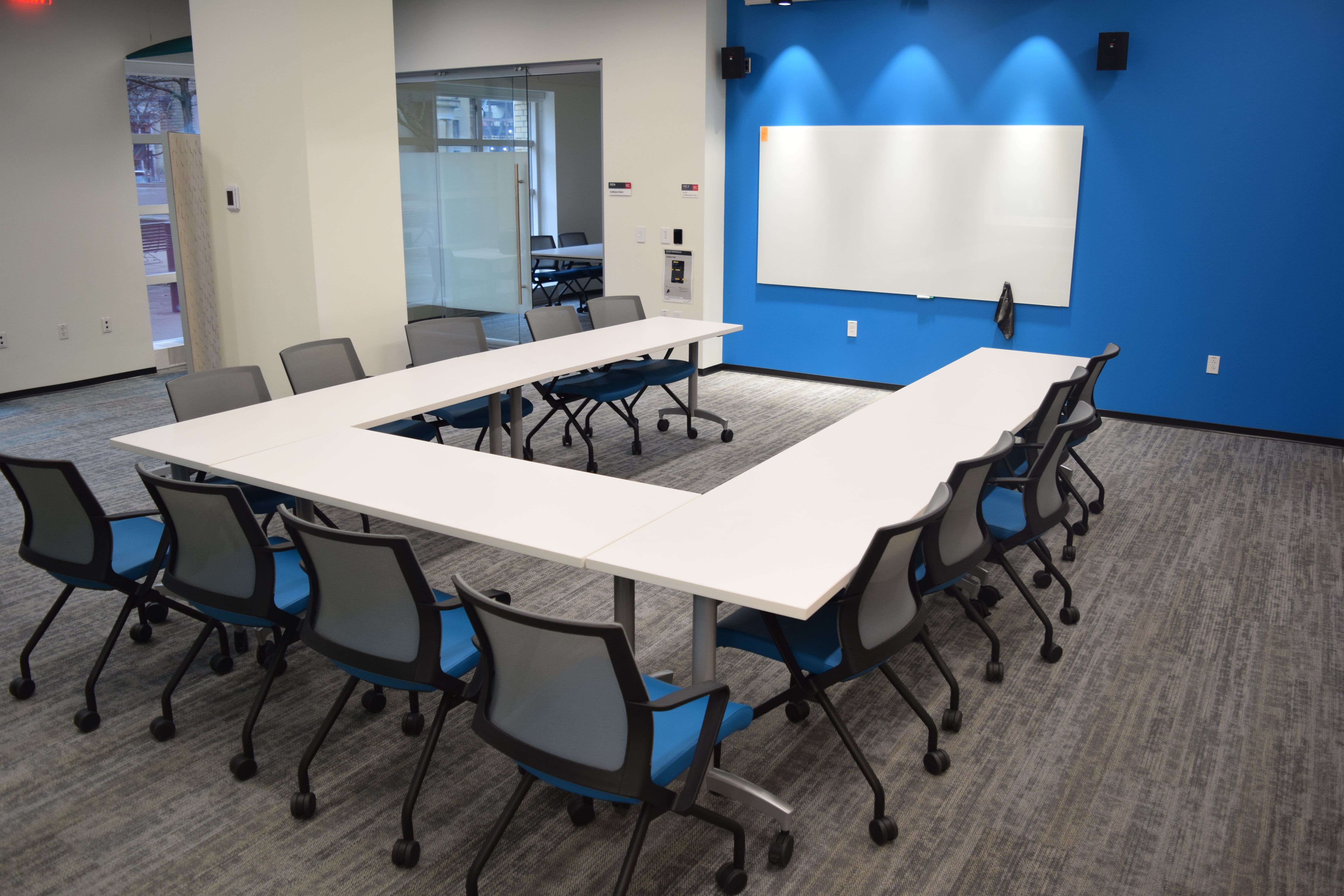 tables and chair in front of a blue wall 