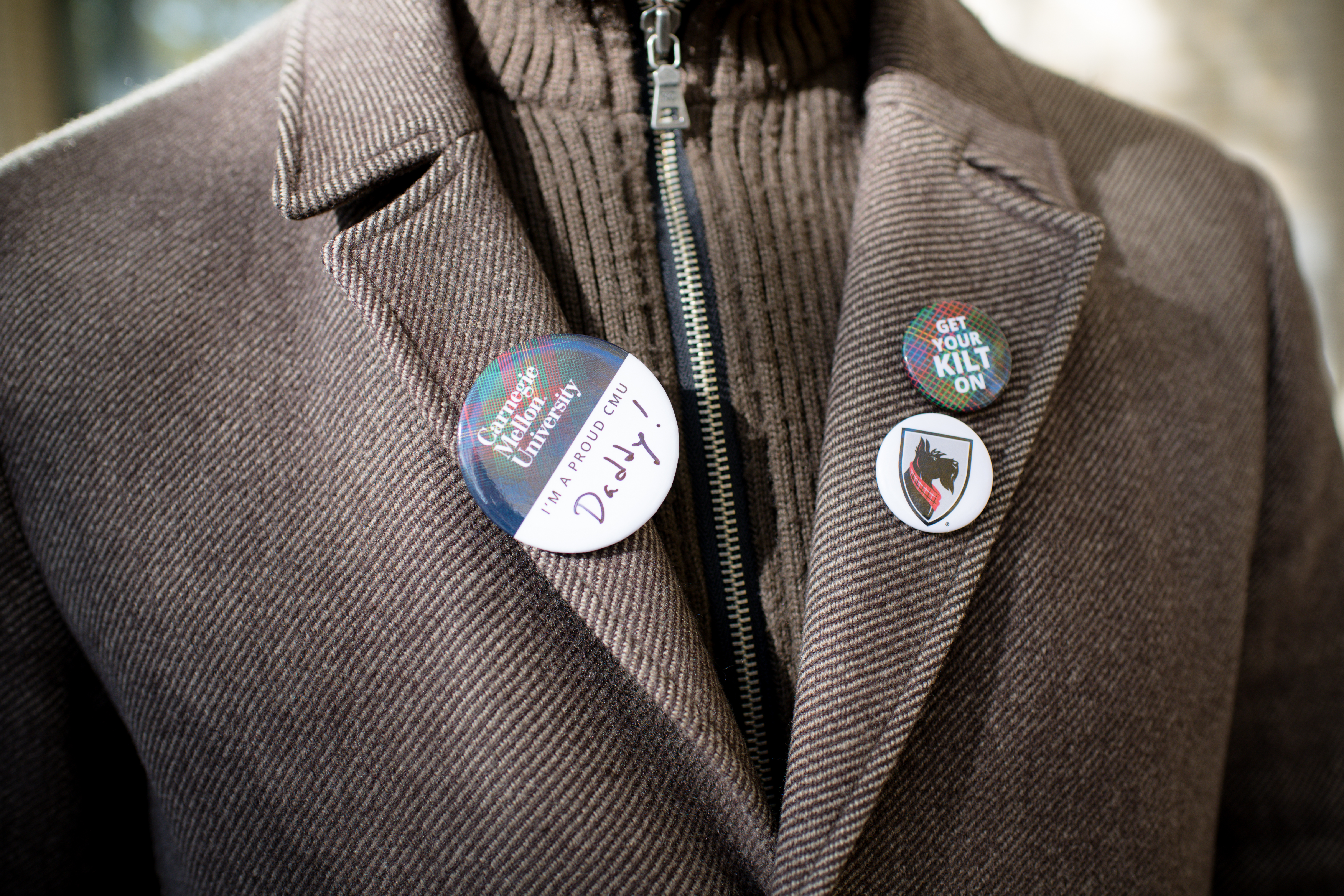 photo of various cmu pins on the lapels of a sportscoat