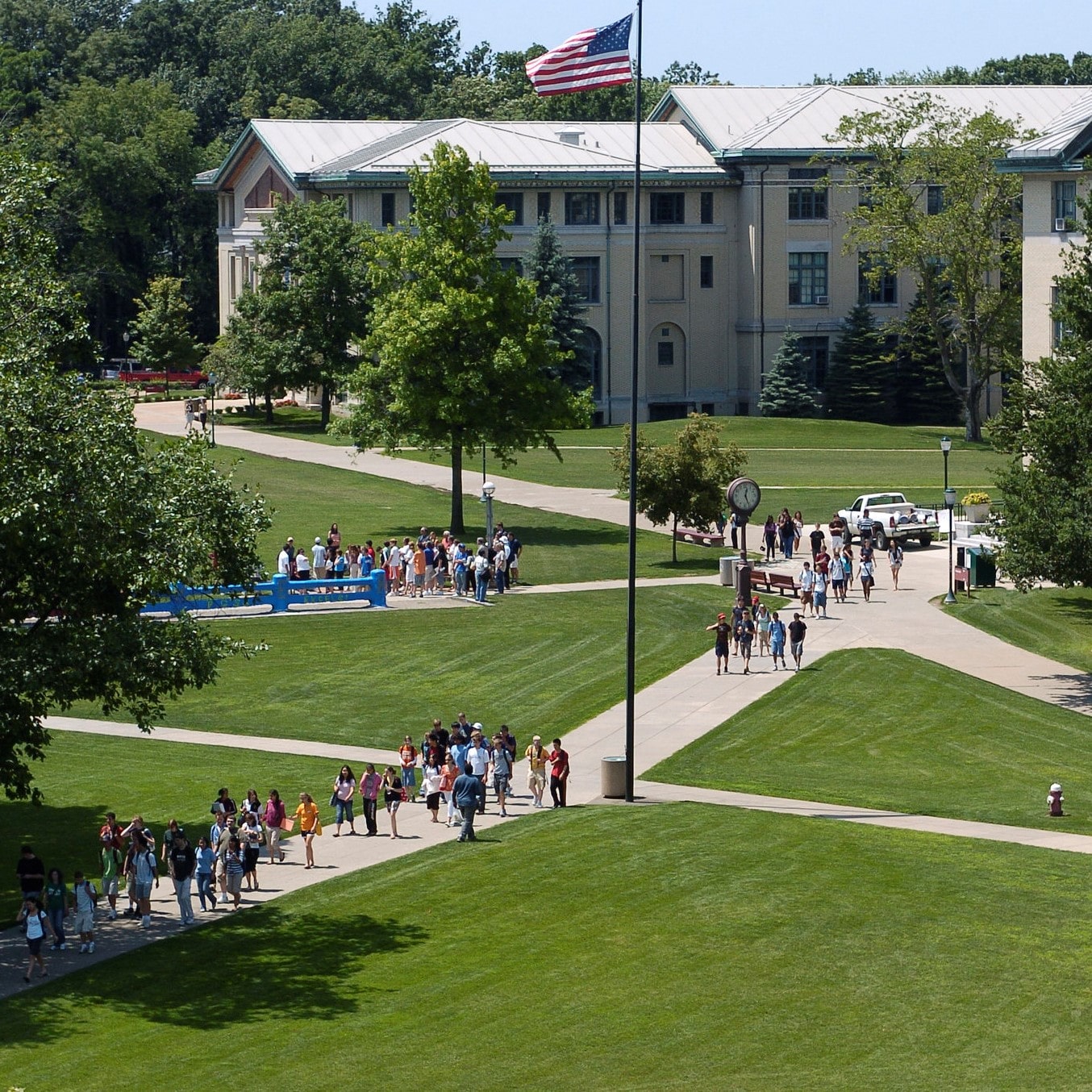 groups of students walking across the cut near the clock