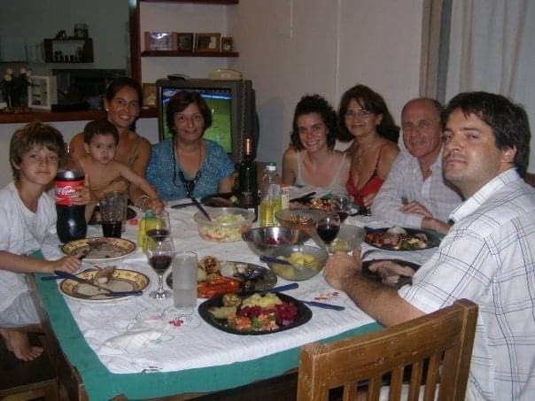 Erin Swift and her host family gather around a dinner table to share a meal.