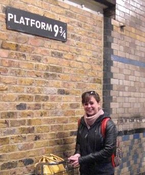 Tess Thrower poses beside the "entrance" to Platform 9 3/4 in London, UK.