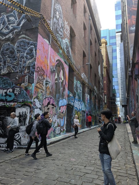Tourists admire graffiti in the famous Hosier Lane