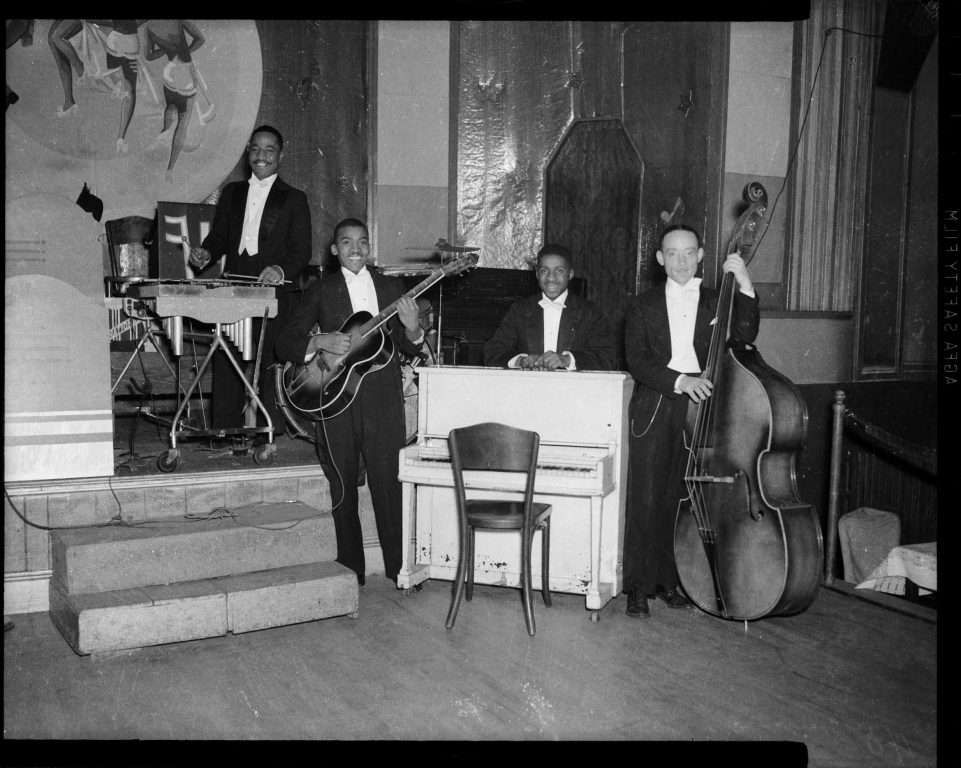 Musicians pose on stage at the Harlem Casino, circa 1939-1940.