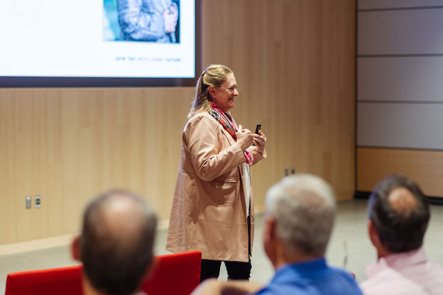 Dean Isabelle Bajeux-Besnainou speaks to a large group of alumni