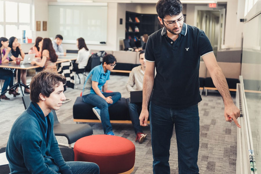 A photo of PhD Tepper students using the chalkboard