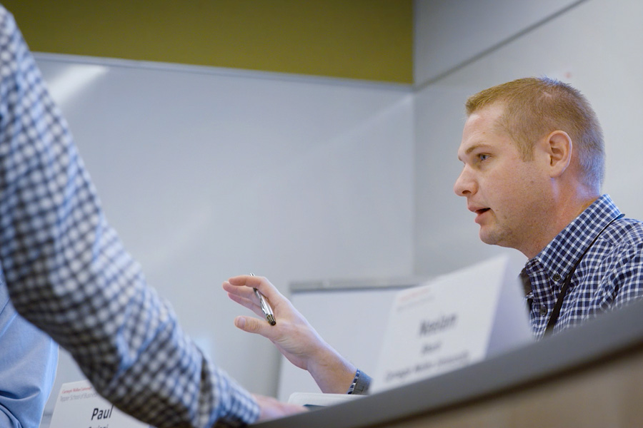 light skinned man with light hair speaking to colleague