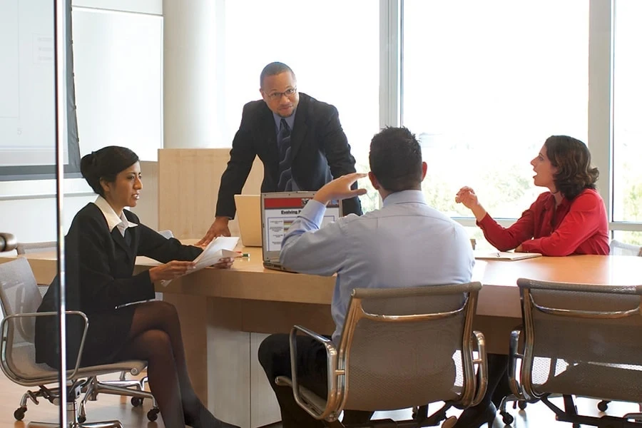 photo of business professionals talking around a conference table