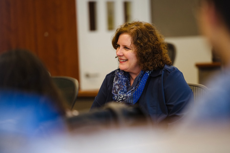 Photo of a woman speaking to other faculty members.