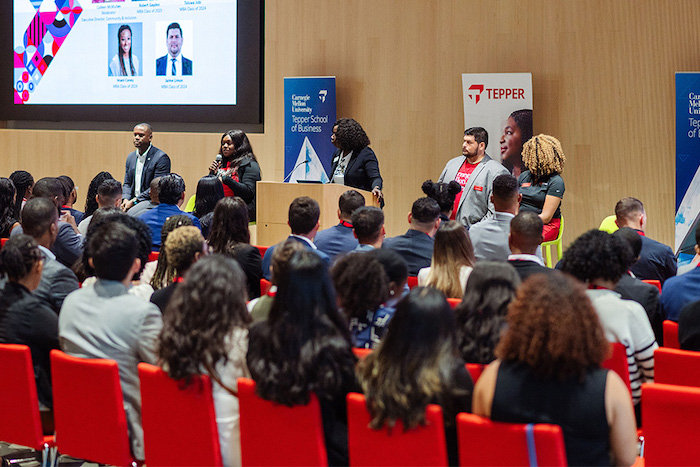 Image of speakers and attendees at an event
