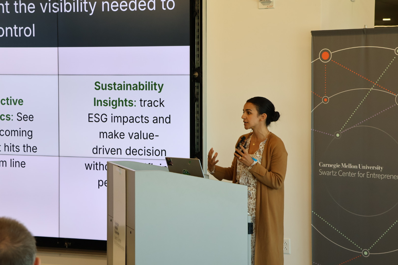 A woman standing in front of a screen presenting