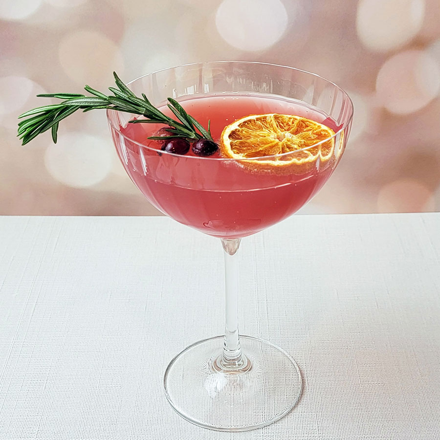 Anacua House pink champagne glass with a pink cocktail and sprig of rosemary