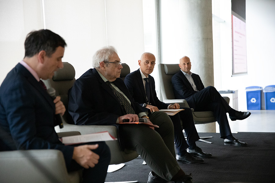 A photo of four men discussing AI and policy