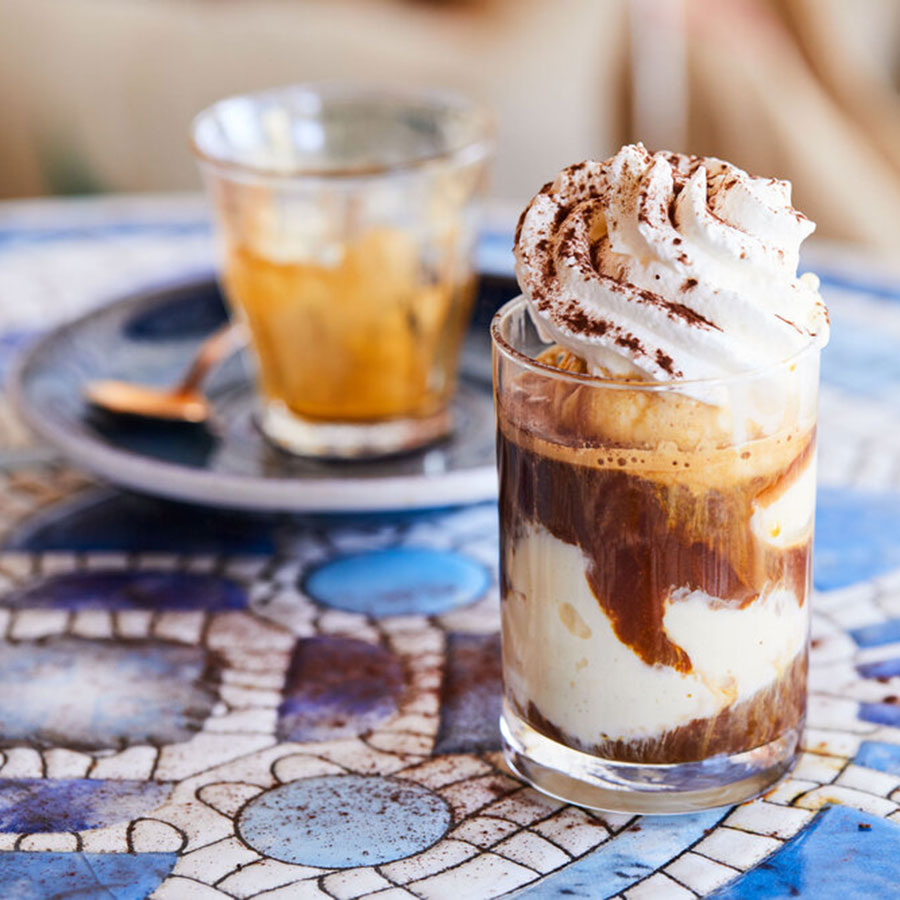 Image of coffee and dessert on blue tiled tabletop