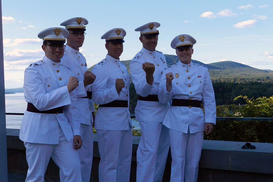 MBA student Josh standing with military colleagues in full uniform against blue sky.