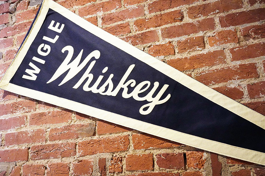 Wigle Whiskey pennant on brick wall