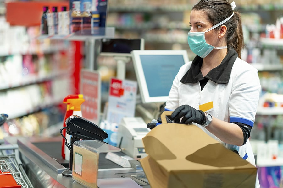 Female ssential worker in store with face mask