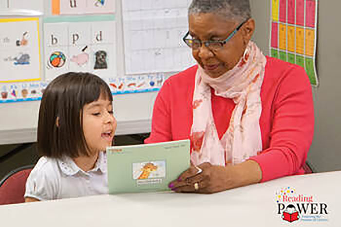 A volunteer and child reading together