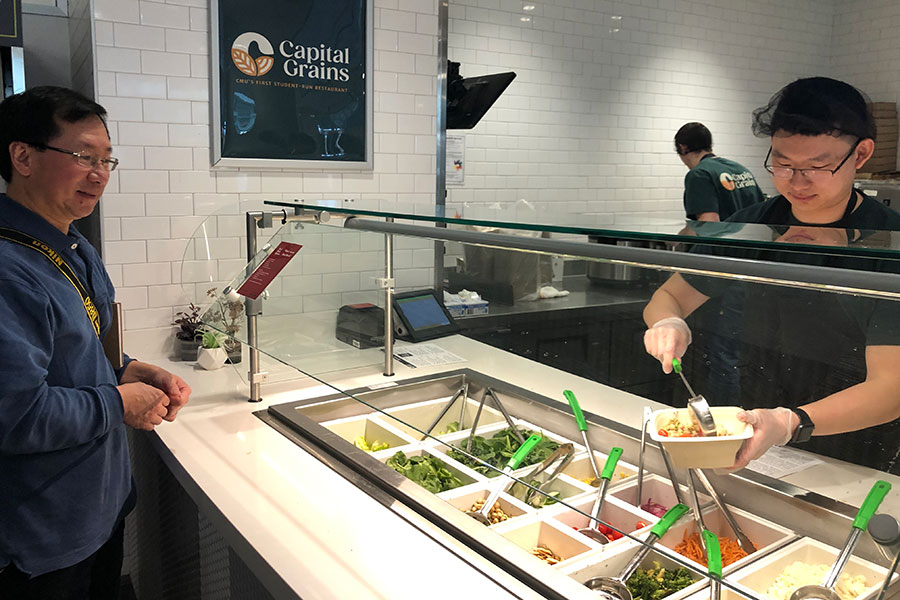 student serving customer at capital grains