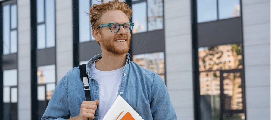 student in front of building