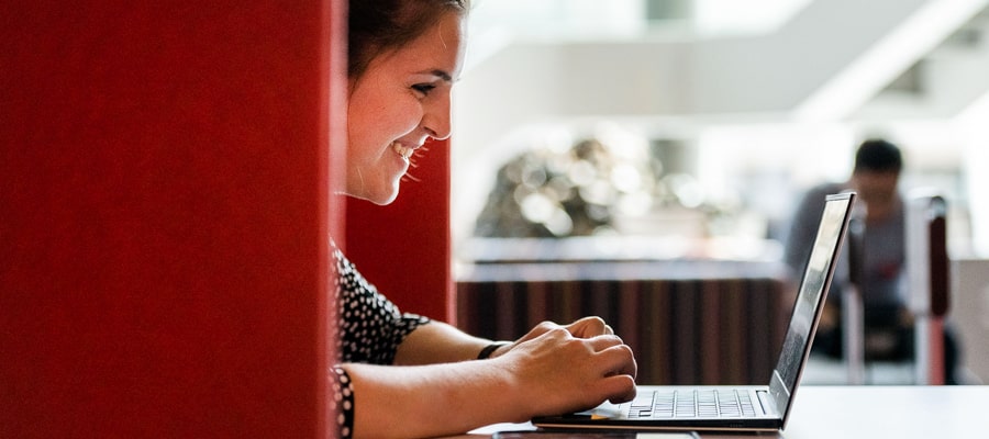 Female MBA student at table in Tepper Quad