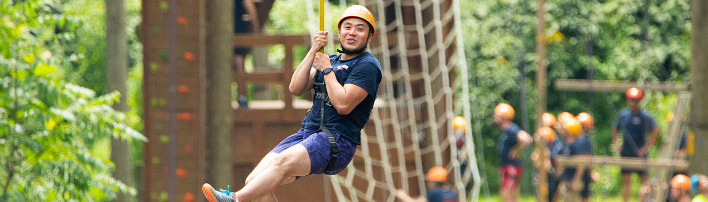 MBA student riding zipline during BaseCamp Team Day