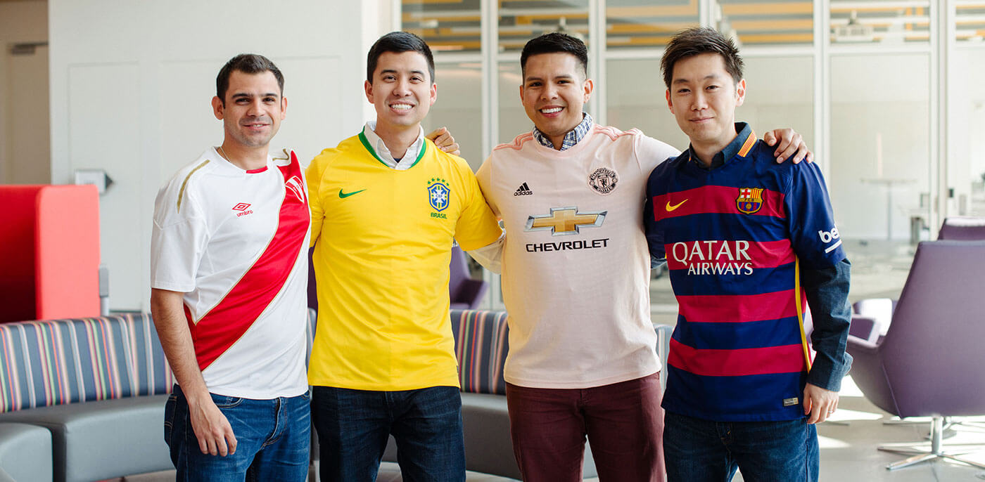 Four members of the Tepper MBA international football club, wearing team kits.
