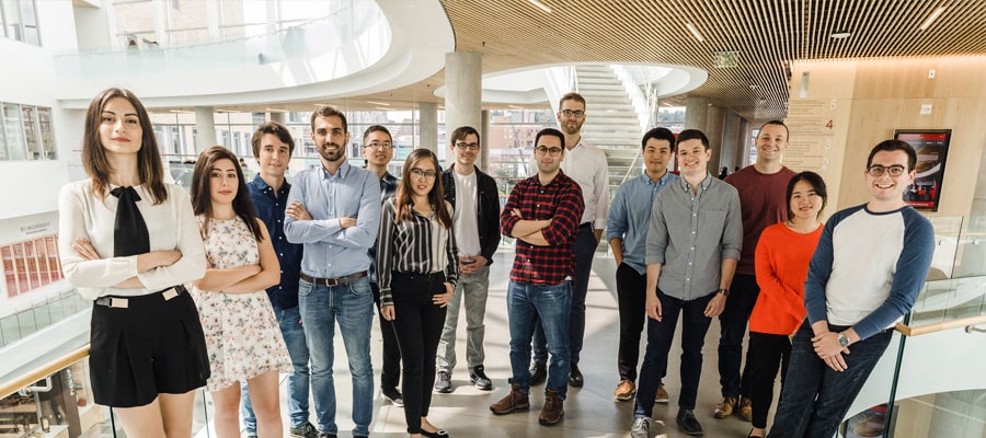 image of group of diverse phd students standing in glass atrium of tepper quad