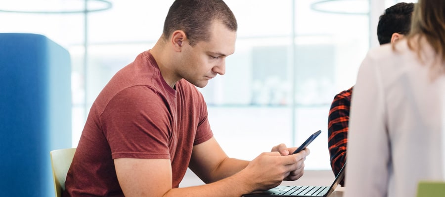 ph.d. student wearing red t-shirt looking at his phone