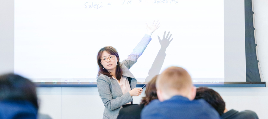 Female facutly member in front of a class of undergraduate students