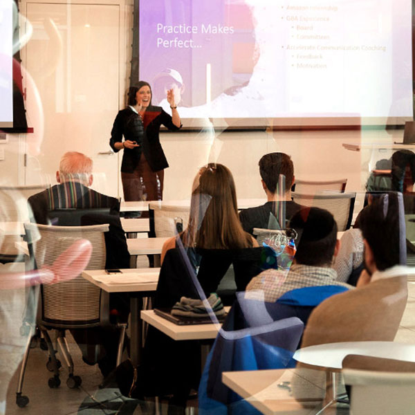 A classroom with students and a female presenter