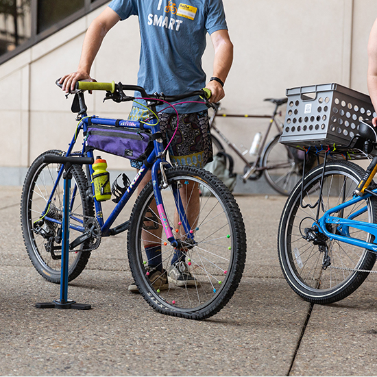 someone standing next to a bike and bike pump