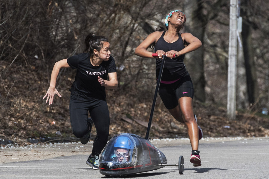 Woman running alongside another women pushing a buggy with extreme intensity
