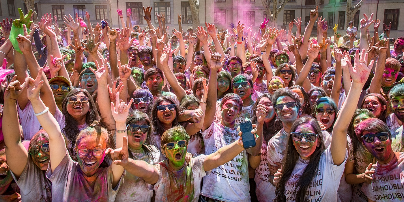 Group of students at Holi Festival covered in colored chalk.