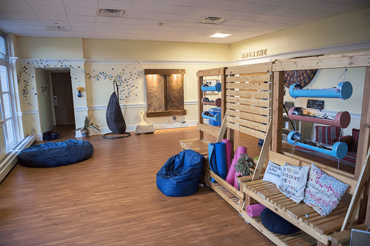 A peek inside the Mindfulness Room, with yoga mats, comfy chairs and art on the walls