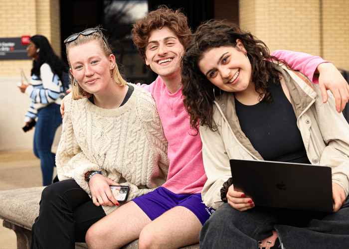 Three students relax on campus together