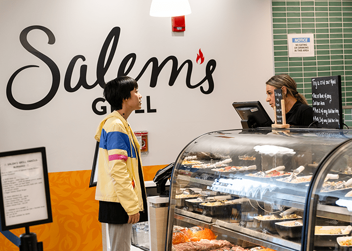 Student pays for their meal at Salem's Grill hot foods bar check-out in Scotty's Market