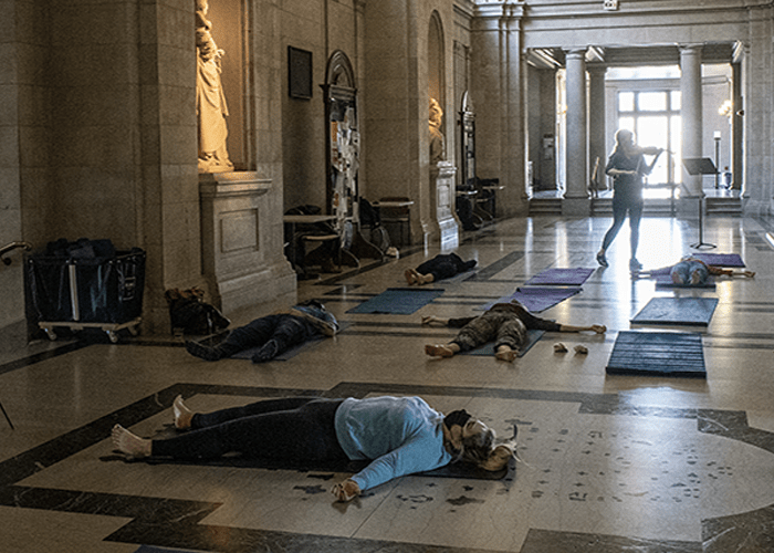 A violinst plays while people do yoga in CFA