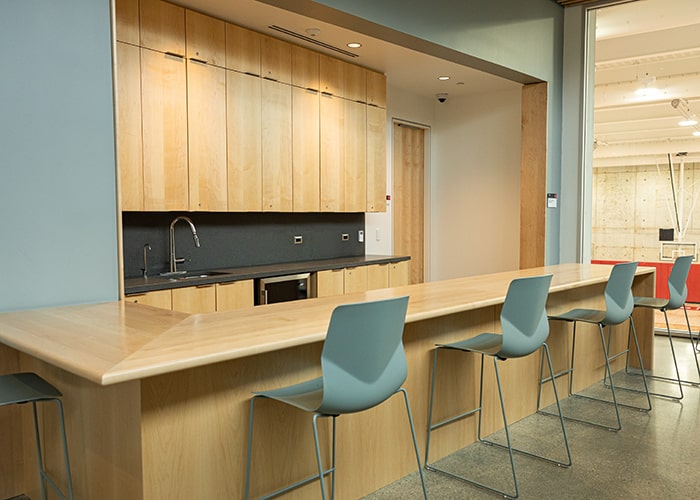 a light wooden snack bar with bar seating and overhead lights