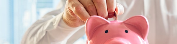 photo of a man putting a penny in a piggy bank
