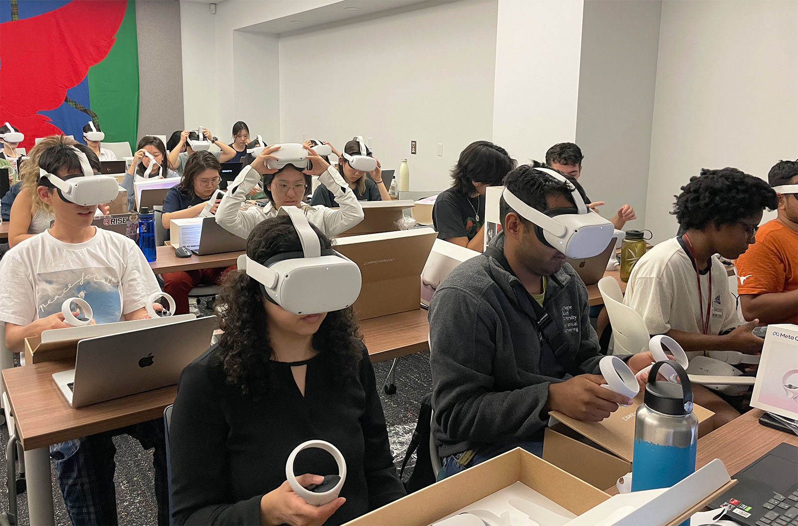 Classroom with approximately 20 students sitting at tables while wearing Virtual Reality headsets